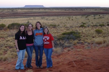 Four travelers standing in the Australian Outback